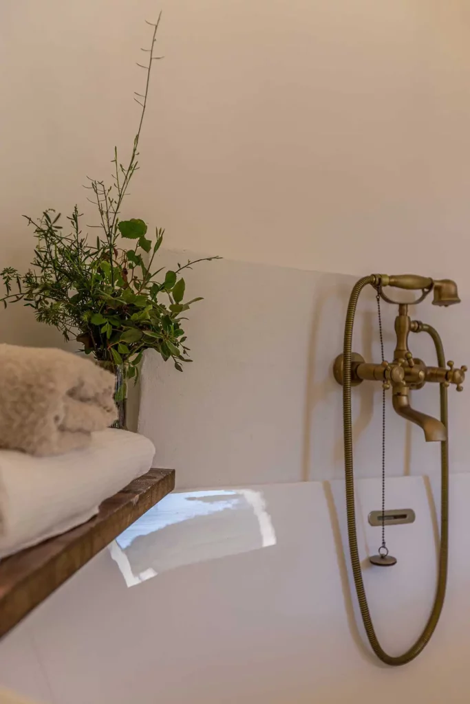 Indulge in luxury living in Soller, Mallorca: Immerse yourself in relaxation with our expert project management, showcasing a designer bathtub and vintage taps in a stunning bathroom.