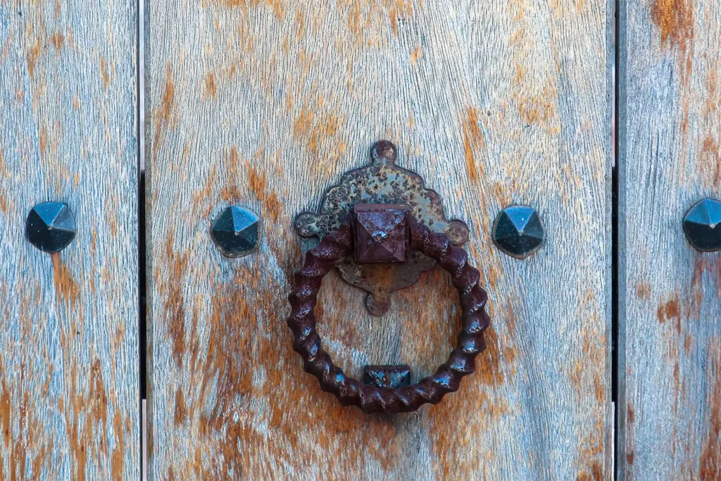 traditional door to a property for sale in Mallorca. Wooden door with rusty handle in Soller.