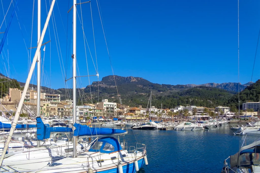 Scenic view of port de soller harbour wit colourful boats docked and majestic mountains in the backdrop